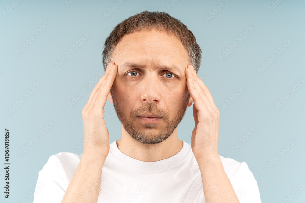 Weary sick man holds temples, troubled by headache, suffering migraine from sleeping disorder or professional burnout. Tired middle aged male with pained expression of mental and physical exhaustion. Weary sick man holds temples, troubled by headache, suffering migraine from sleeping disorder or professional burnout. Tired middle aged male with pained expression of mental and physical exhaustion.