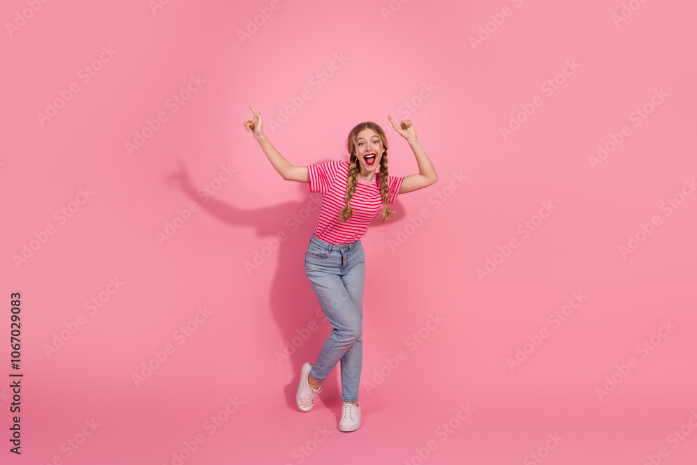 Chic young woman in casual attire sitting on a white block, holding a smartphone, against a vibrant pink background Chic young woman in casual attire sitting on a white block, holding a smartphone, against a vibrant pink background