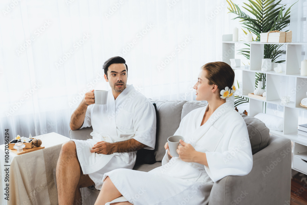 Beauty or body treatment spa salon vacation lifestyle concept with couple wearing bathrobe relaxing with drinks in luxurious hotel spa or resort room. Vacation and leisure relaxation. Quiescent Beauty or body treatment spa salon vacation lifestyle concept with couple wearing bathrobe relaxing with drinks in luxurious hotel spa or resort room. Vacation and leisure relaxation. Quiescent