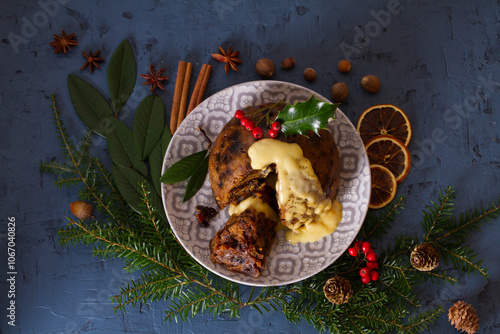 Fruit cake pudding with custard and Christmas decorations. Fruitcake ball, traditional dessert on Christmas. Top view