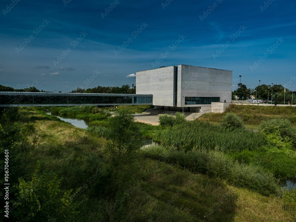 Modern building with lush greenery and blue sky. Modern building with lush greenery and blue sky.