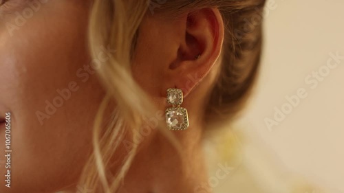 ear of a woman with a jeweled earring with a diamond