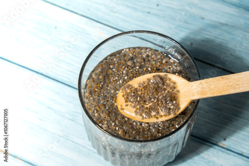 Preparing superfood water drink rich in Omega 3 fatty acids. Pouring coconut water. Adding soaked chia seeds and lemon detox Breakfast. Clean eating, weight loss, dieting food concept Vegetarian