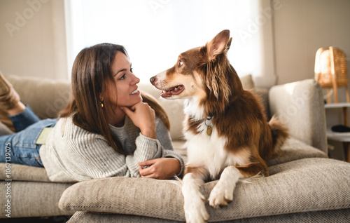 woman with cute fluffy Australian Shepherd dog at home in living room