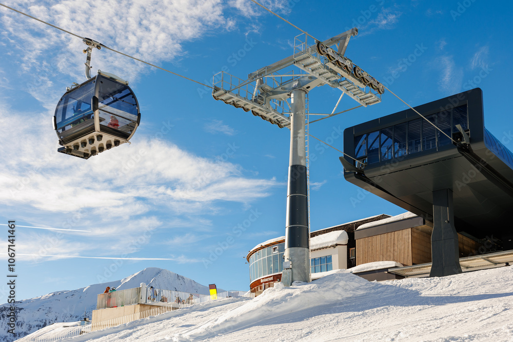 Φωτογραφία Ski lift gondola cable car station operates in luxury alpine ski resort on a snowy winter day with mountain background and a clear blue sky