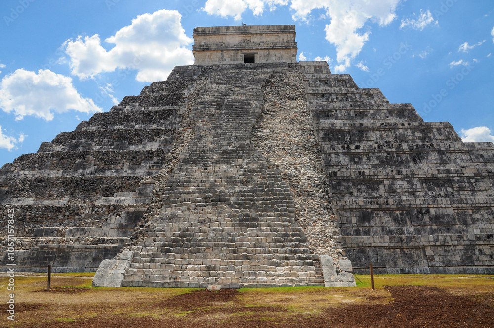 Majestic Chichen Itza pyramid under blue sky, highlighting ancient architecture Majestic Chichen Itza pyramid under blue sky, highlighting ancient architecture