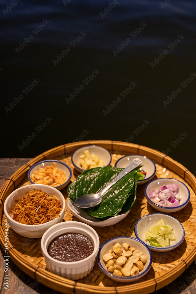 Miang kham: A royal leaf wrap appetizer a traditional from Thailand. Thai herbal appetizer wrapping consisting of dried shrimp, roasted coconut, beans, ginger, lime and chili into fresh Betel leaf. Miang kham: A royal leaf wrap appetizer a traditional from Thailand. Thai herbal appetizer wrapping consisting of dried shrimp, roasted coconut, beans, ginger, lime and chili into fresh Betel leaf.