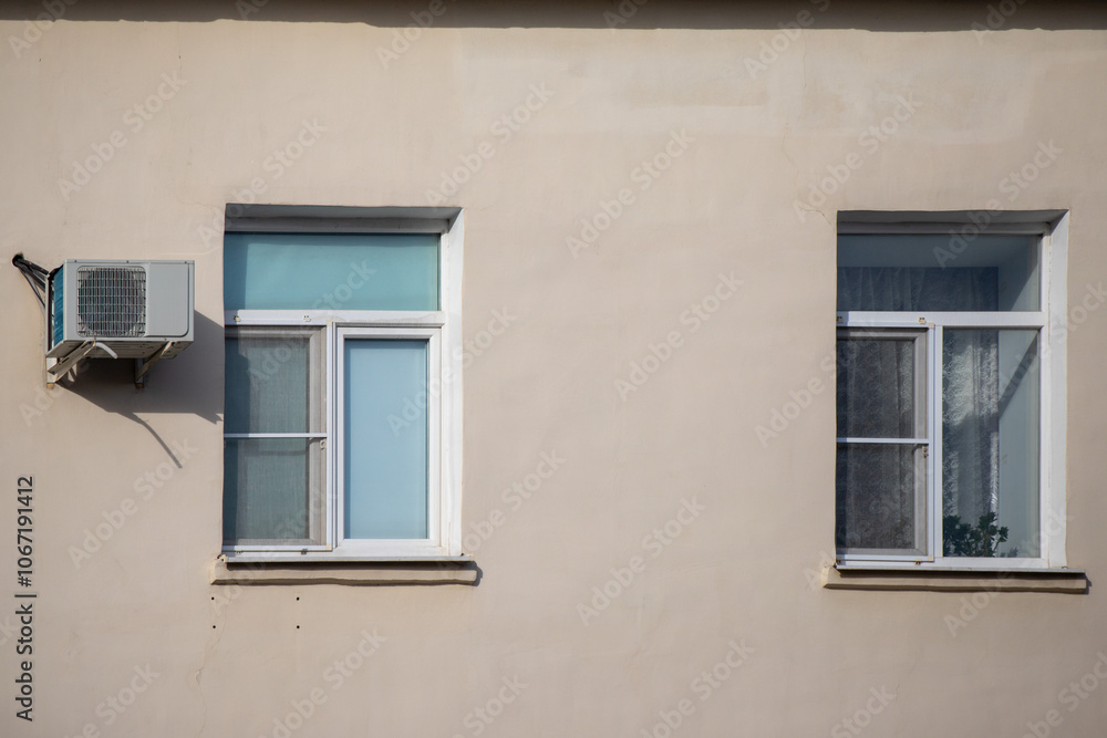 A window with a white air conditioner on the wall A window with a white air conditioner on the wall