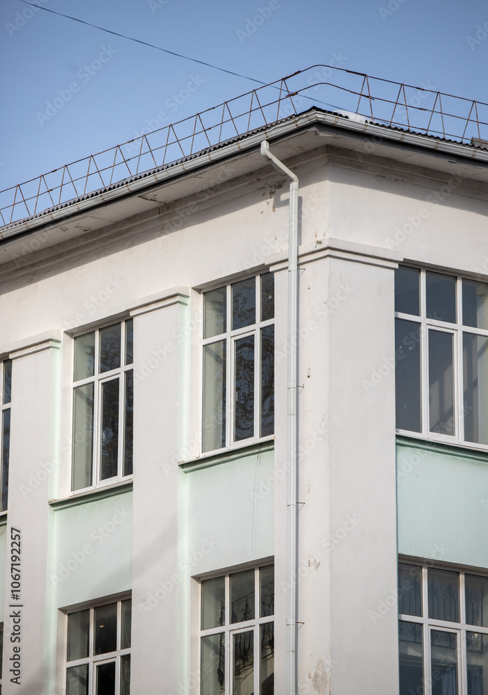A tall building with a white roof and a white wall A tall building with a white roof and a white wall