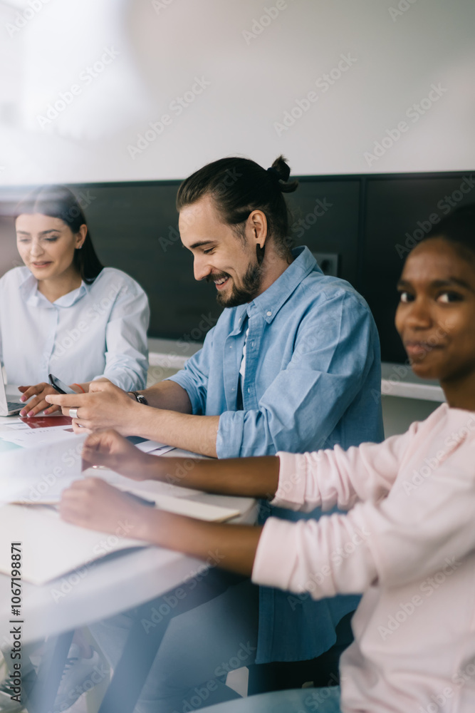 Smiling coworkers sitting table in office space Smiling coworkers sitting table in office space