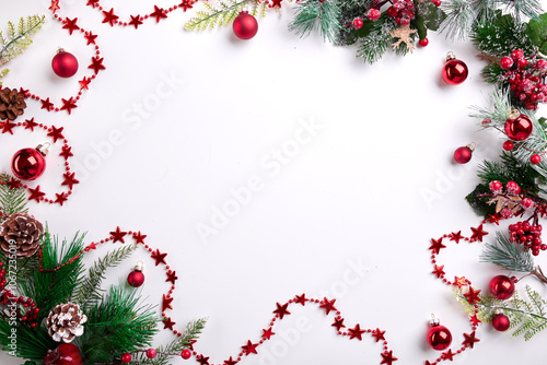 This image presents a charming mix of red and green Christmas ornaments, including glossy balls and shimmering stars, artfully arranged on a crisp white background, perfect for festive decoration. photo