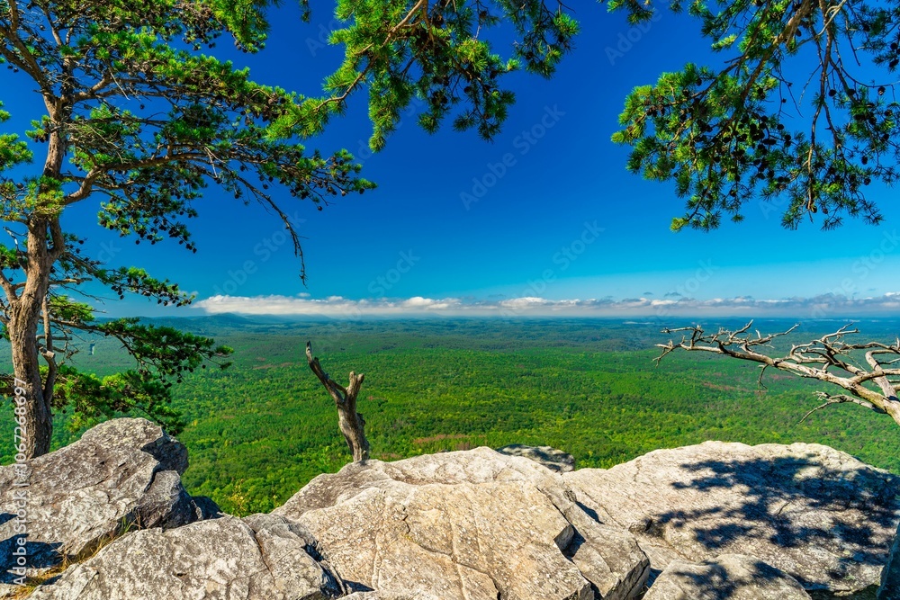 Pulpit Rock in Cheaha State Park, AL, under a clear blue sky, surrounded by lush greenery Pulpit Rock in Cheaha State Park, AL, under a clear blue sky, surrounded by lush greenery
