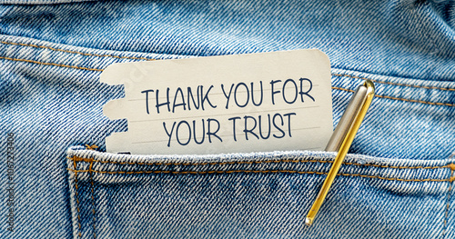 Thank You For Your Trust text on a sheet from a notebook peeking out of a pocket with a pen