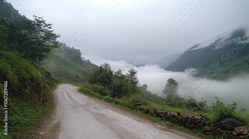 A quiet, foggy mountain road, with the mist clinging to the rocky terrain and disappearing into the clouds above