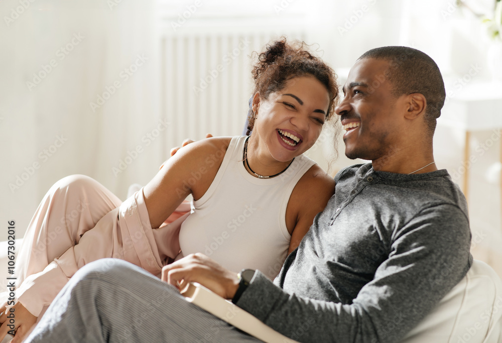 Romantic happy african american couple relaxing on couch at home, smiling loving mature spouses resting in cozy living room interior, embracing on sofa, enjoying weekend time together, copy space Romantic happy african american couple relaxing on couch at home, smiling loving mature spouses resting in cozy living room interior, embracing on sofa, enjoying weekend time together, copy space