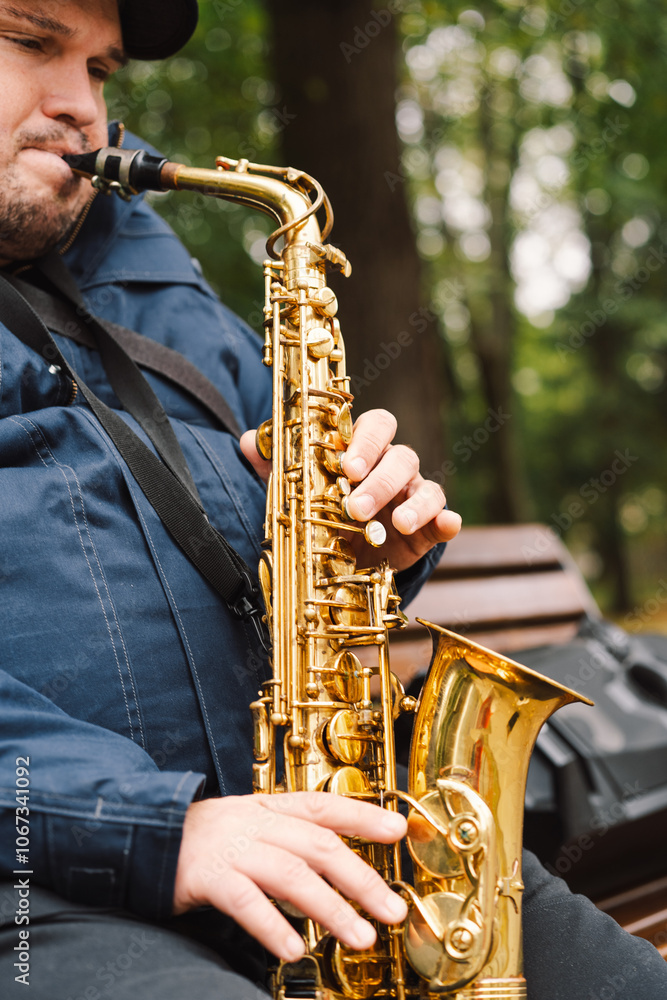 Fototapeta premium A saxophonist performs in a serene park during autumn while seated on a bench surrounded by fallen leaves