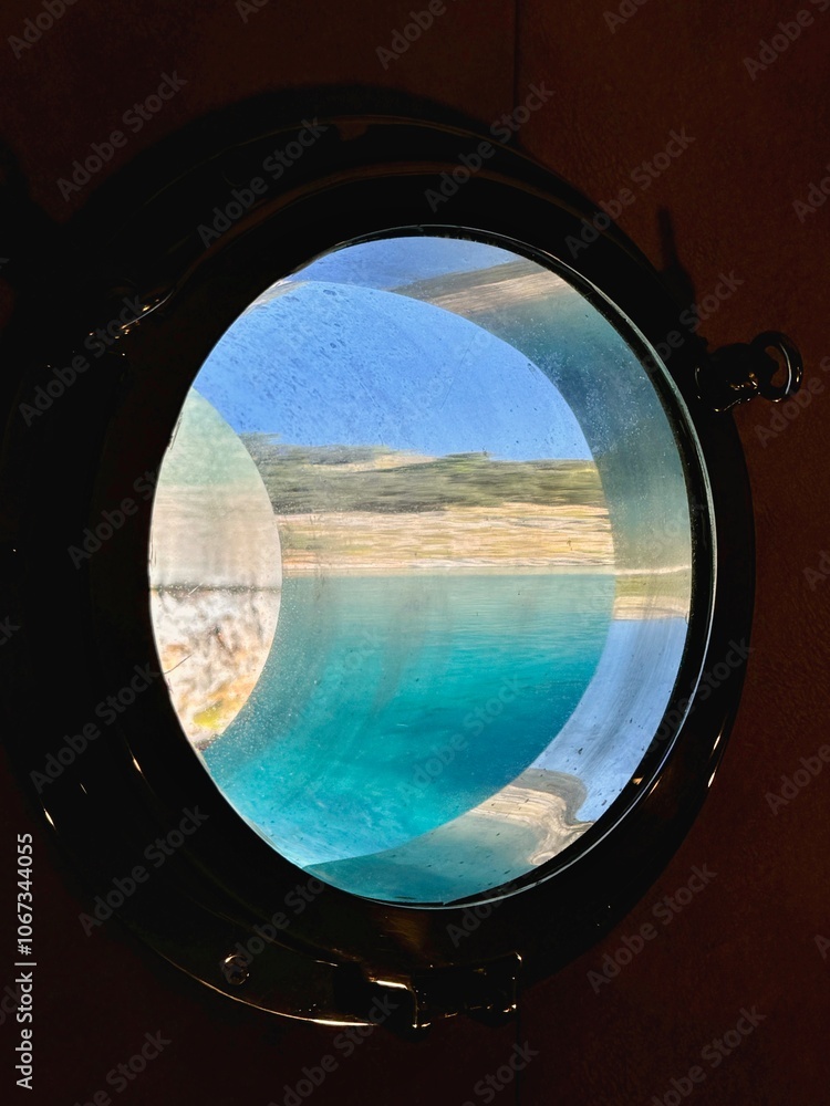 The beautiful view of the water and the sky through the cabin port window in Mediterranean Sea