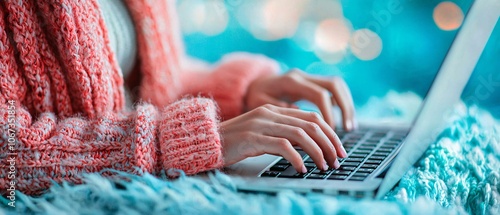 A close-up of a person typing on a laptop while seated on a cozy blanket, creating a warm and inviting workspace atmosphere. photo