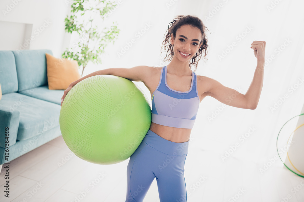 Confident young woman training with exercise ball in bright modern home Confident young woman training with exercise ball in bright modern home