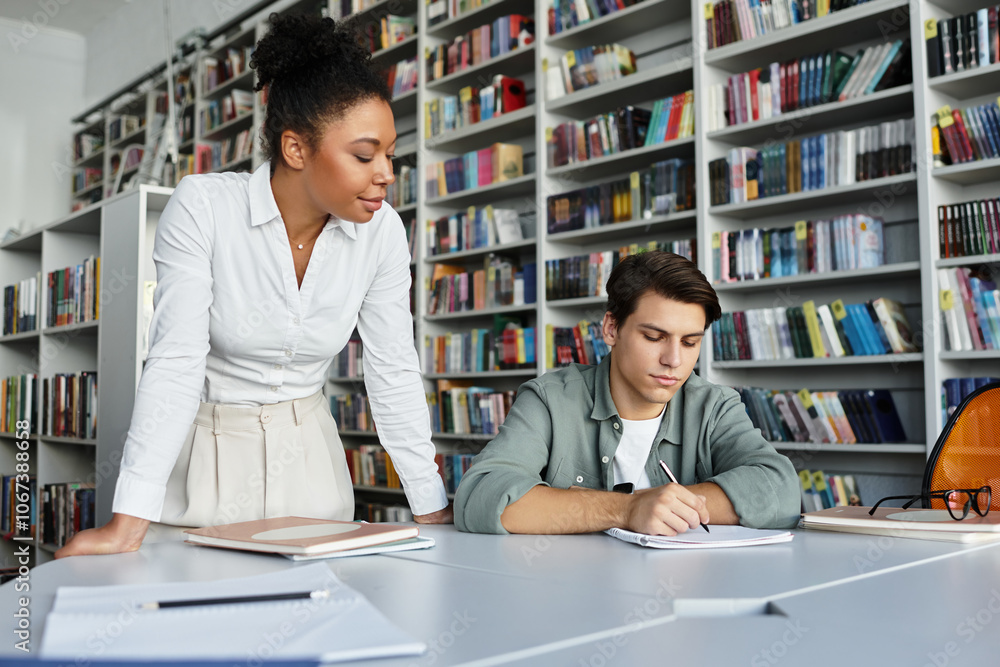 In a warm library, a passionate teacher supports her young student’s learning journey. In a warm library, a passionate teacher supports her young student’s learning journey.