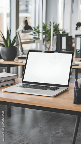 Wallpaper Mural A vertical mockup of a white screen laptop placed on a wooden desk at a workplace. The background contains a few office elements, such as a potted plant, a lamp, and a binder. The floor is grey. Torontodigital.ca