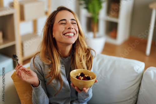 Fotografía Happy woman enjoying healthy breakfast with oatmeal and berries at home
