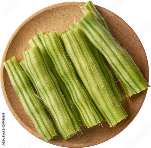 pieces of peeled moringa or drumstick on wooden tray isolated white background, highly nutritious superfood vegetable ready for cooking in curries, soups or stews taken from above photo