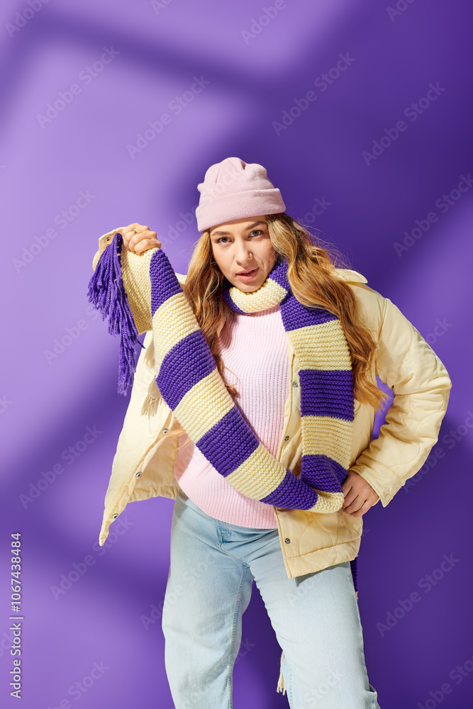 A young plus size woman showcases her winter fashion with a bright scarf and playful pose. A young plus size woman showcases her winter fashion with a bright scarf and playful pose.