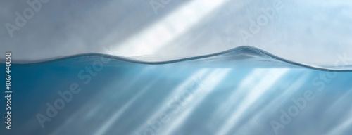 Obraz na płótnie Blue water surface with sunlight reflections against a white background, showing a gentle wave curve. w salonie