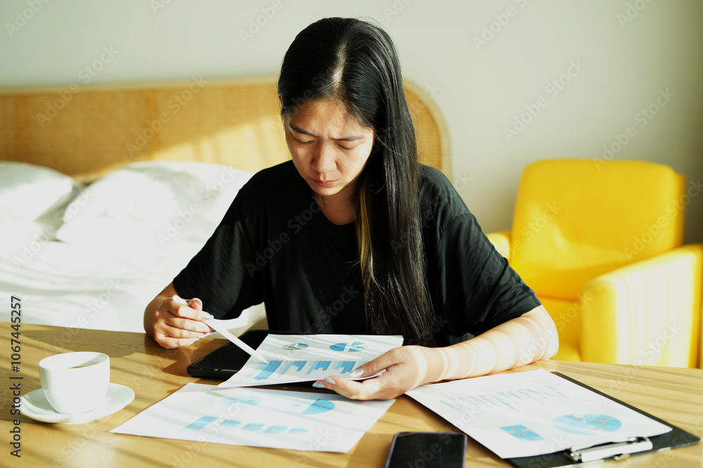Tired and unhappy female manager working at hotel room with paper documents and feeling headache. Exhausted business woman is working even on trip and this is a concept of stressful life and deadline. Tired and unhappy female manager working at hotel room with paper documents and feeling headache. Exhausted business woman is working even on trip and this is a concept of stressful life and deadline.
