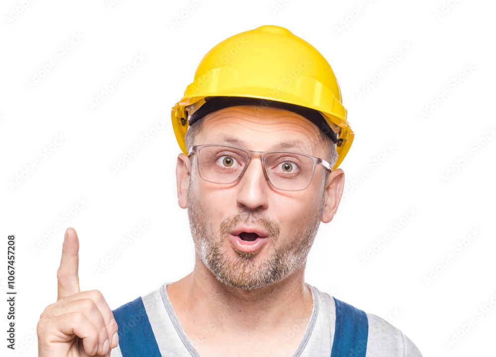 Idea gesturing. Surprised middle-aged construction worker pointing up with his finger, isolated on white background. Amazed repairman with open mouth. Craftsman against white wall Idea gesturing. Surprised middle-aged construction worker pointing up with his finger, isolated on white background. Amazed repairman with open mouth. Craftsman against white wall