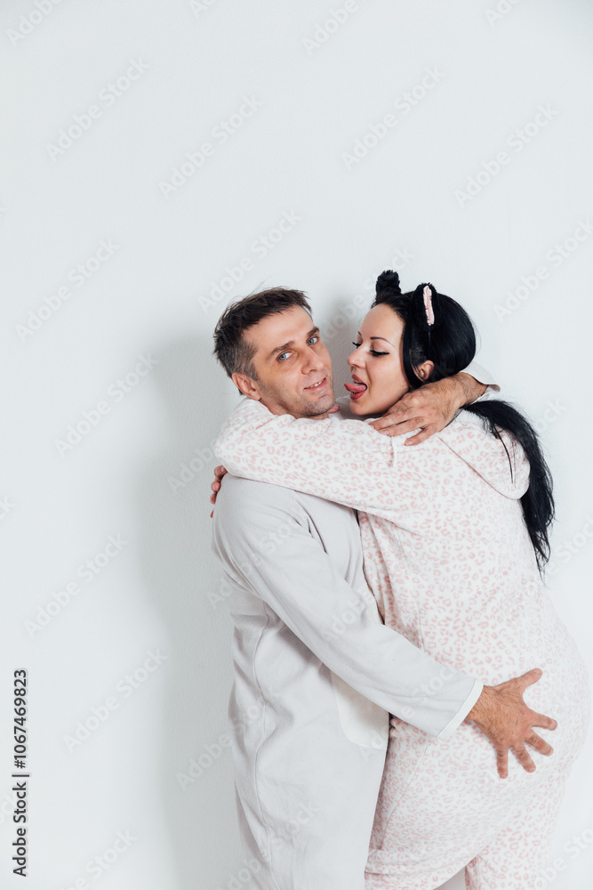 Man and woman in pajamas hugging family in bedroom Man and woman in pajamas hugging family in bedroom