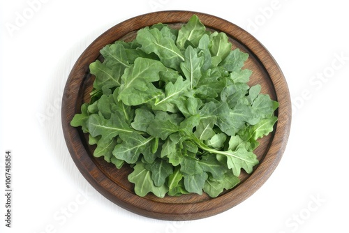 Fresh arugula salad on a wooden plate overhead view photo