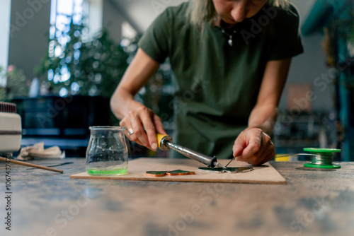 Photography in a large green workshop on a woman with green hair creates decorative flowers