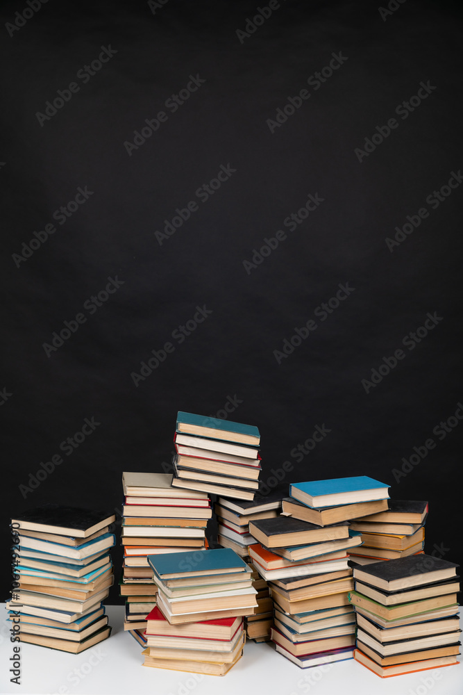 stacks of educational books to study in the university library on a black background stacks of educational books to study in the university library on a black background