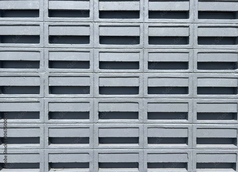 A close-up view of a textured concrete block wall, showcasing the arrangement of hollow blocks in a uniform pattern. A close-up view of a textured concrete block wall, showcasing the arrangement of hollow blocks in a uniform pattern.