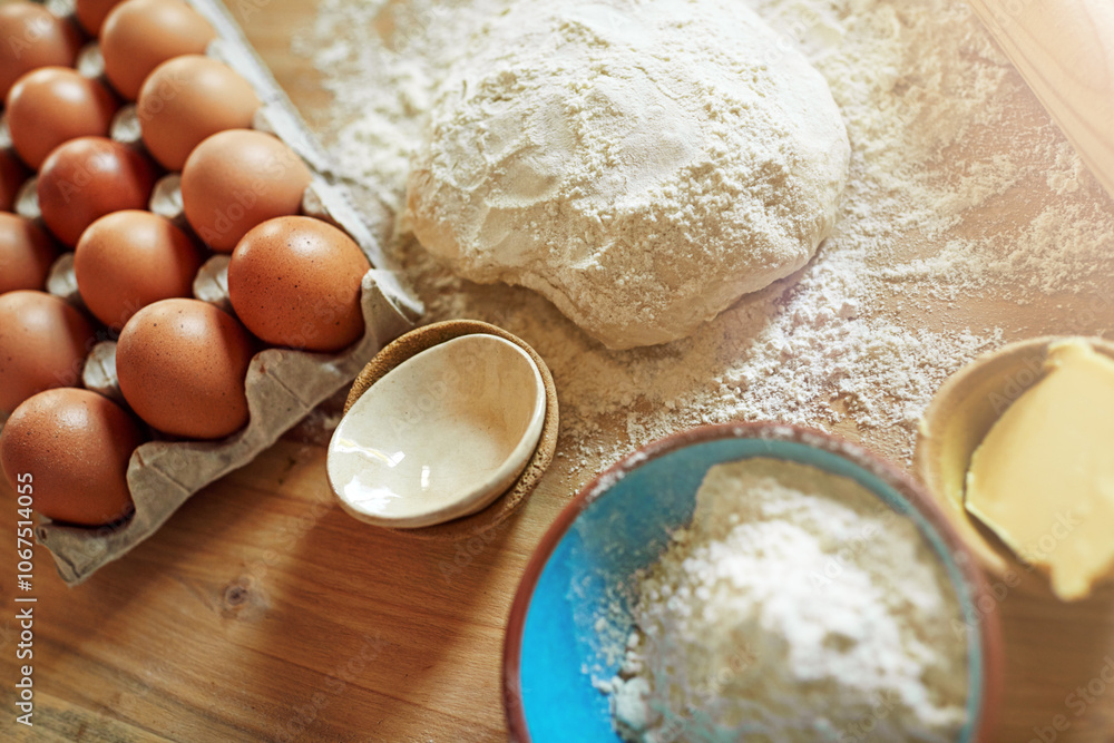 Above, eggs and flour with dough for baking, cooking or bread production in kitchen. Food, butter and nutrition with rolling pin and ingredients in home for dessert, culinary and pastry preparation Above, eggs and flour with dough for baking, cooking or bread production in kitchen. Food, butter and nutrition with rolling pin and ingredients in home for dessert, culinary and pastry preparation