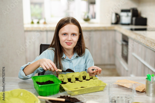 Child girl used egg tray for sow seed and grow plants. Reuse garbage. Recycle, sustainable lifestyle and home garden life concept.