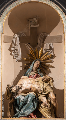 PAVIA, ITALY - SEPTEMBER 8, 2024: The carved byroque polychorme statue of Pieta (Deposition) in the church Basilica di San Michaele Maggiore by unknown artist.