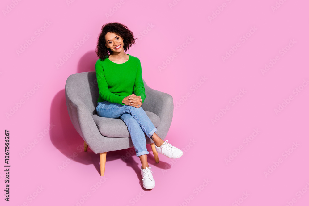 Full body photo of attractive young woman sit soft armchair dressed stylish green clothes isolated on pink color background Full body photo of attractive young woman sit soft armchair dressed stylish green clothes isolated on pink color background