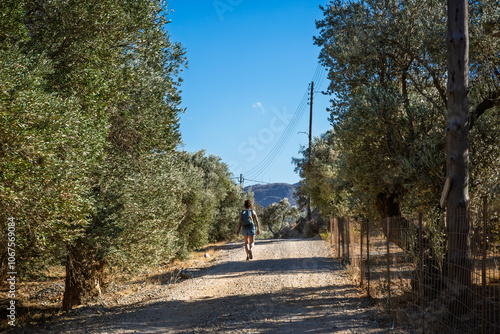 Frau wandert auf Kreta in Griechenland an Bäumen entlang photo