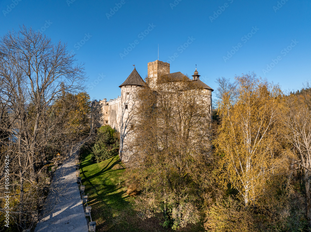 Poland. Medieval castle in Niedzica, dating to 14th century (upper castle) in autumn in October. Trees in beautiful fall colors. Sunset light. Aerial drone view