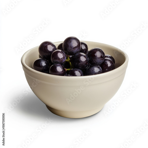 A bowl of purple grapes, isolated on a white background, showcasing a juicy fruit