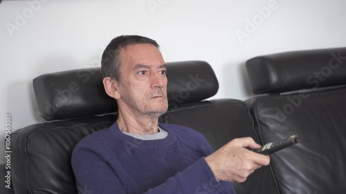 Senior citizen changing tv channel with remote