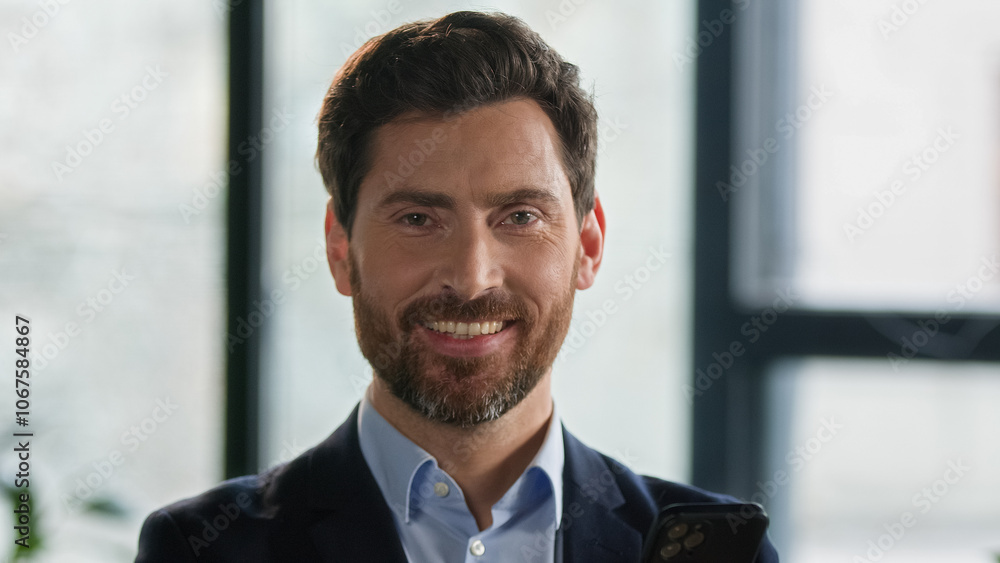 Close-up caucasian bearded man looking side and turning gaze to camera smiling successful mature businessman entrepreneur leader ceo employer professional manager posing indoors male business portrait Close-up caucasian bearded man looking side and turning gaze to camera smiling successful mature businessman entrepreneur leader ceo employer professional manager posing indoors male business portrait