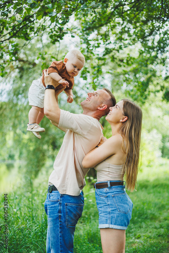 A young married couple with a small son on a walk. A happy family with a child.