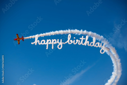 Plane writes Happy Birthday with smoke trail in blue sky, adding festive charm