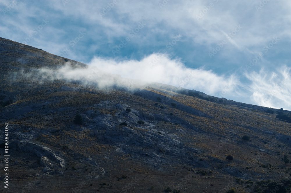 Majestic mountain landscape with swirling clouds and clear sky Majestic mountain landscape with swirling clouds and clear sky