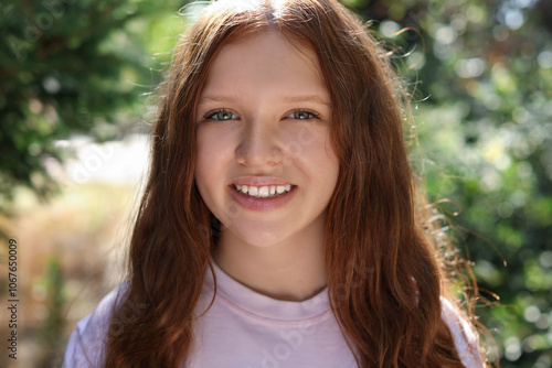 Portrait of happy teenage girl with long hair outdoors