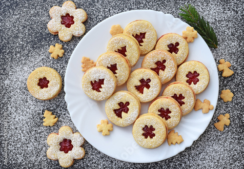 Linzer cookies on a plate and around it